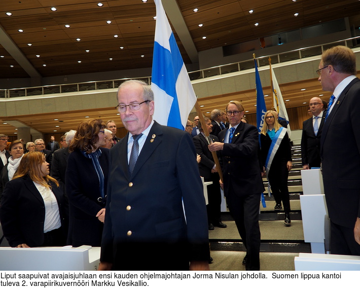Liput saapuivat avajaisjuhlaan ensi kauden ohjelmajohtajan Jorma Nisulan johdolla.  Suomen lippua kantoi tuleva 2. varapiirikuvernri Markku Vesikallio.