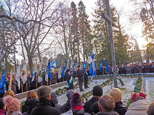 Leijonaklubien lippuja Pyhn Laurin kirkon sankarihautausmaan reunamalla. 
